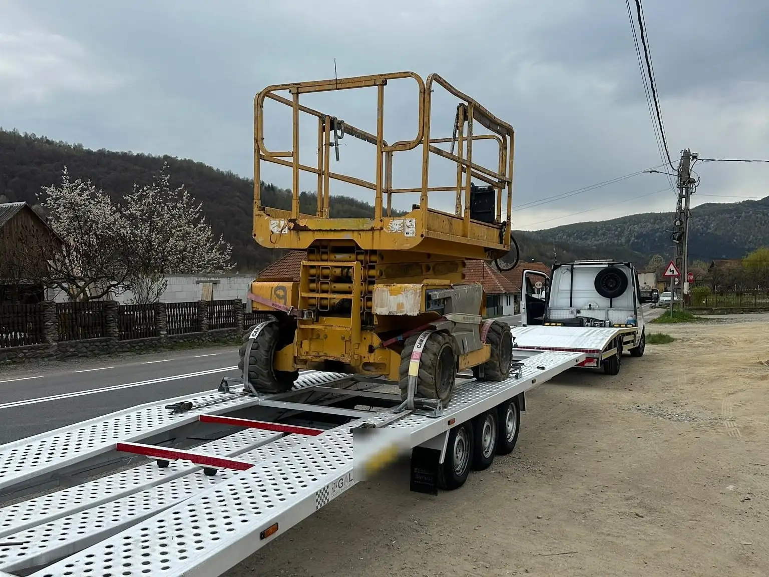 Nacelă foarfecă fixată pe trailerul cu trei axe